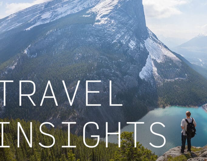 A backpacker overlooking a mountain and a lake with the caption "Travel Insights".