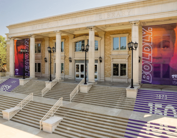 Banners on the side of a Texas Christian University building that read "Lean on. Boldly."