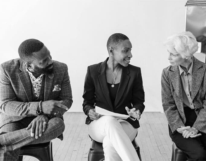 Three professionals sitting and talking.
