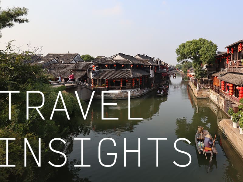 A gondola traveling down a canal in a Chinese city with the caption "Travel Insights".